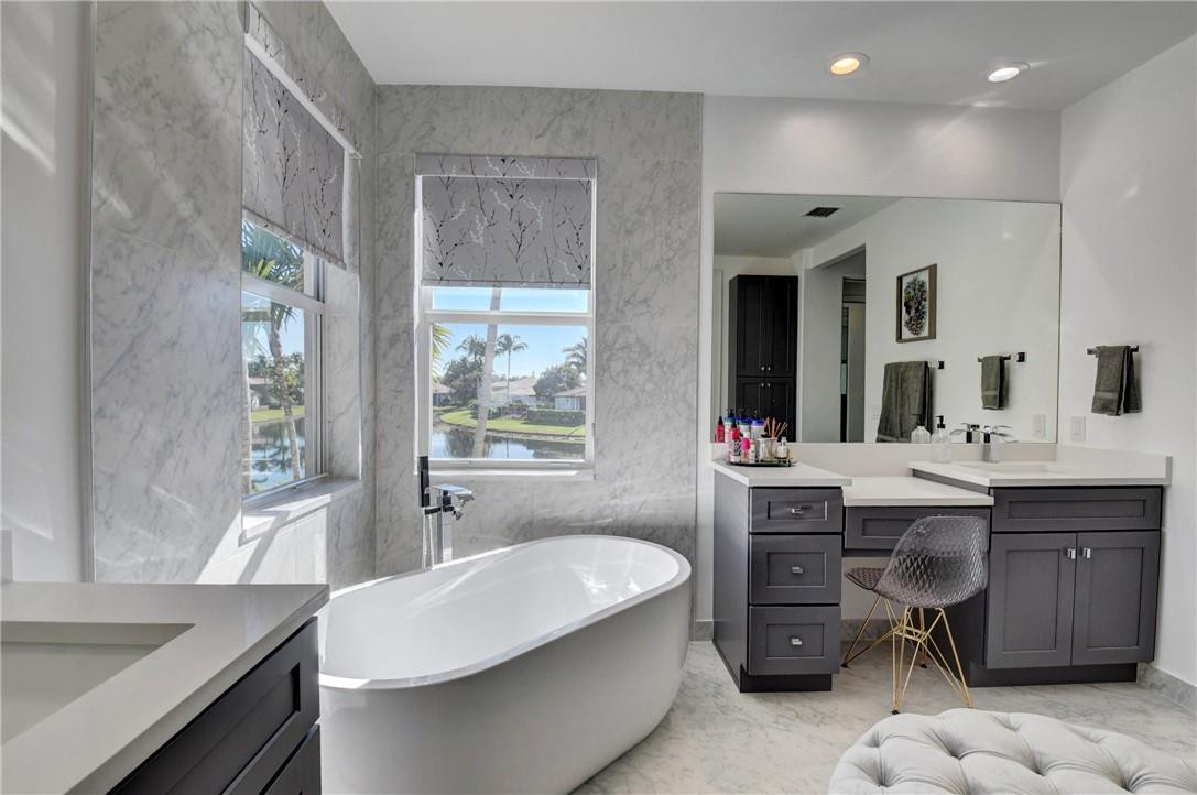11750 Bayfield Drive Boca Raton, FL 33498 - Photo 58 of 70 a bathroom with a sink double vanity granite tub shower and a mirror
