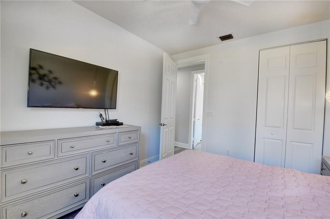 11750 Bayfield Drive Boca Raton, FL 33498 - Photo 63 of 70 a bedroom with a bed and a flat screen tv in it