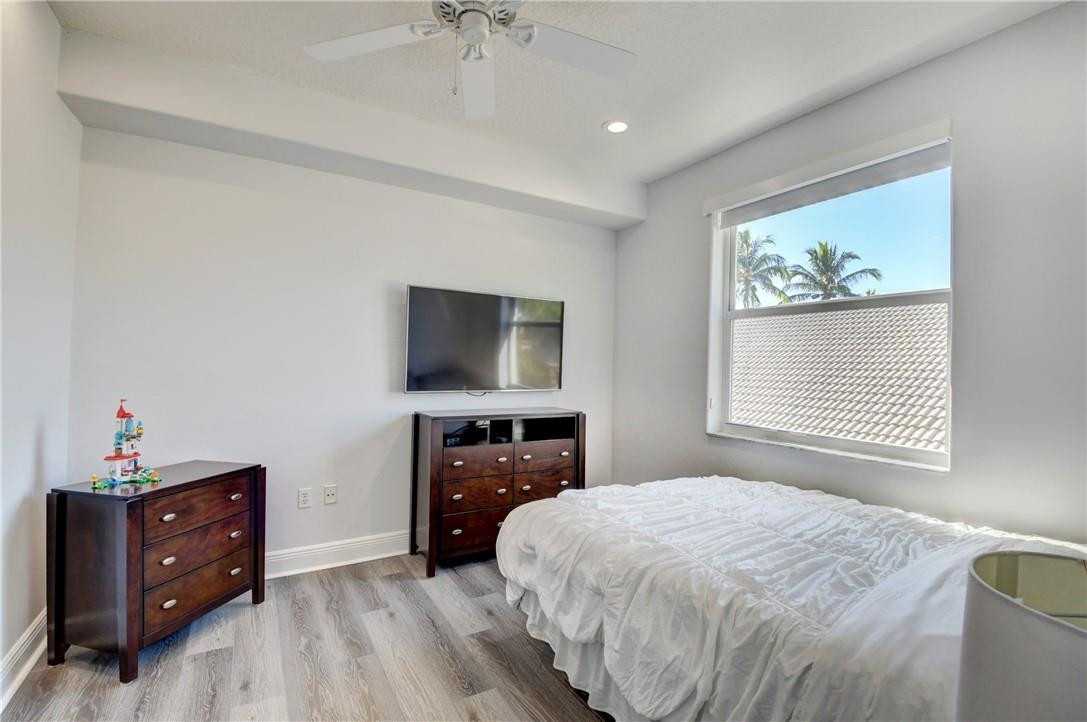 11750 Bayfield Drive Boca Raton, FL 33498 - Photo 64 of 70 a bedroom with a bed and a flat screen tv