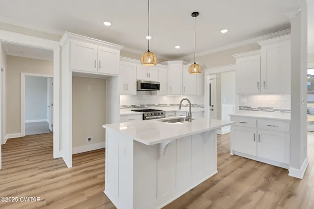 a kitchen with kitchen island a sink stainless steel appliances and cabinets