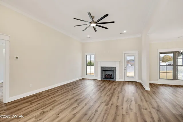 a view of empty room with wooden floor fireplace and windows