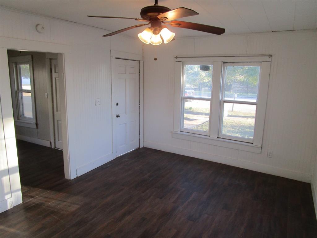220 Southwest 5th Street Hamlin, TX 79520 - Photo 18 of 28 a view of an empty room with wooden floor and a window