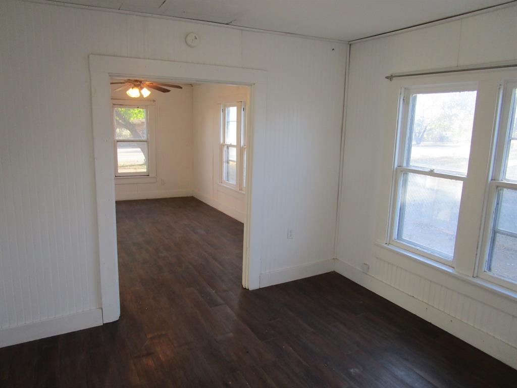 220 Southwest 5th Street Hamlin, TX 79520 - Photo 20 of 28 an empty room with wooden floor and windows