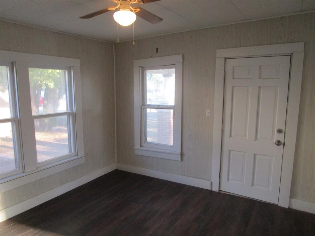 220 Southwest 5th Street Hamlin, TX 79520 - Photo 21 of 28 an empty room with wooden floor and windows