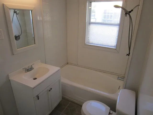 an empty room with wooden floor & closet area