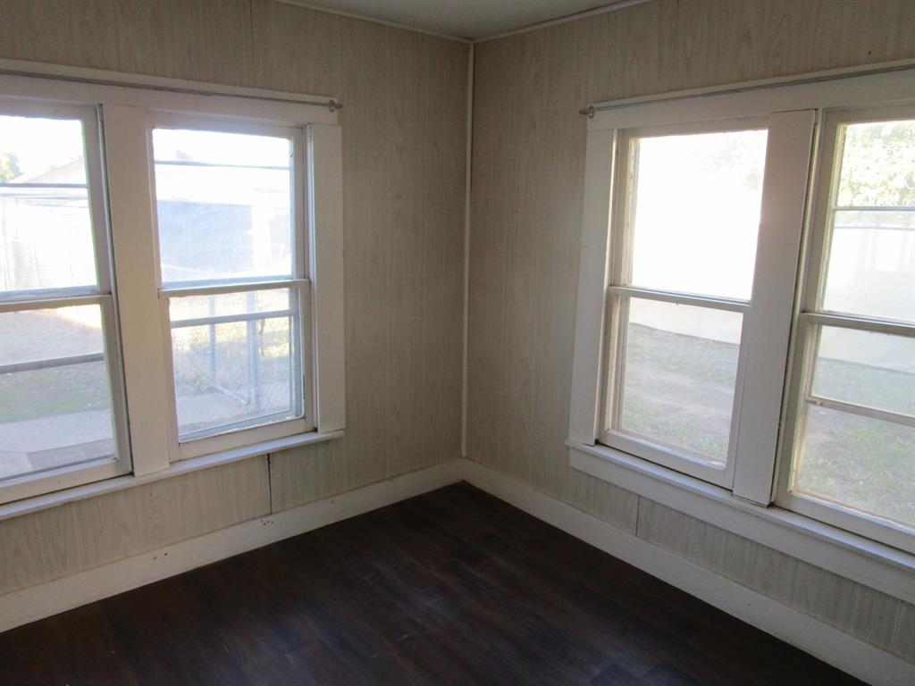 220 Southwest 5th Street Hamlin, TX 79520 - Photo 24 of 28 a view of an empty room with wooden floor and a window