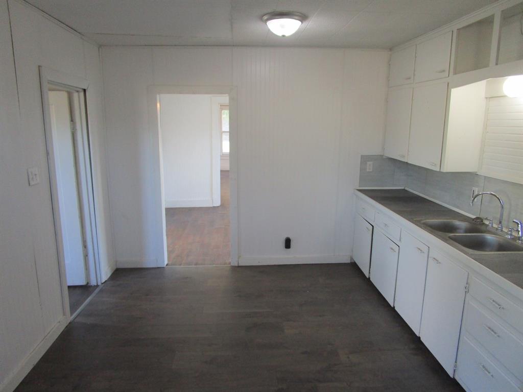 220 Southwest 5th Street Hamlin, TX 79520 - Photo 28 of 28 a view of a kitchen with a sink and dishwasher with wooden floor