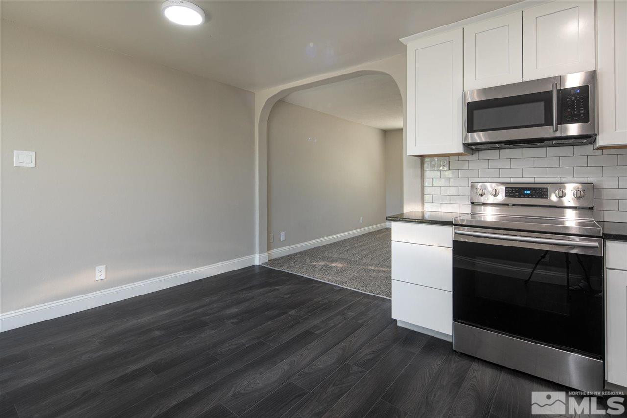 1520 Surf Way Reno, NV 89503 - Photo 12 of 32 a kitchen with granite countertop a stove and a microwave