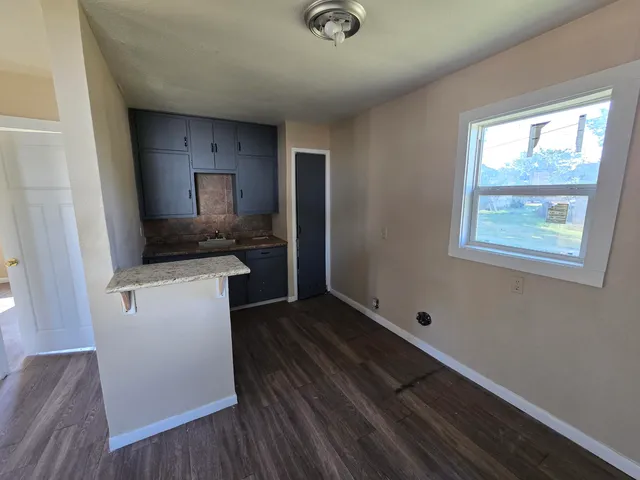 a view of an empty room window and wooden floor