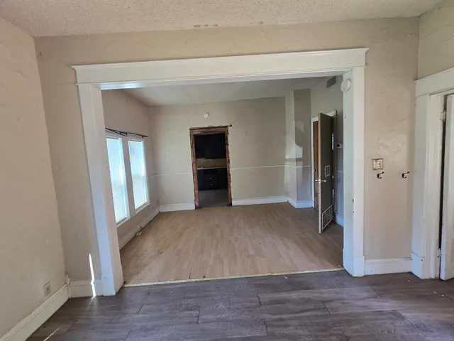 an empty room with wooden floor and closet