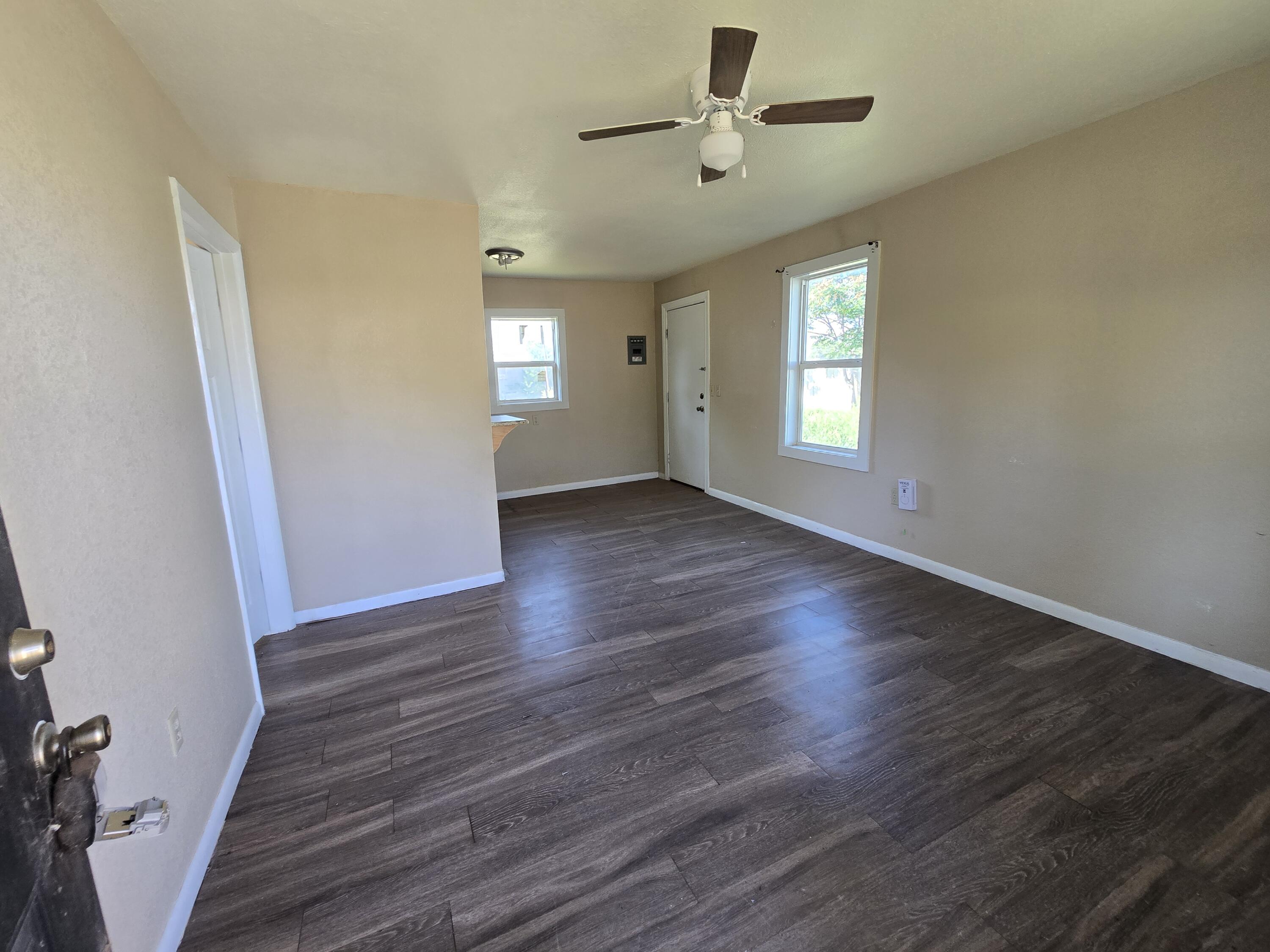 711 Fresno Plainview, TX 79072 - Photo 10 of 13 an empty room with wooden floor and windows