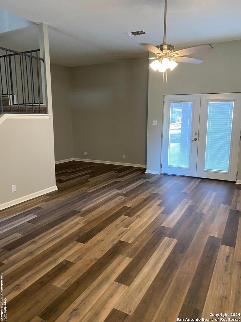 8404 Forest Ridge Drive San Antonio, TX 78239 - Photo 17 of 18 an empty room with wooden floor chandelier and windows