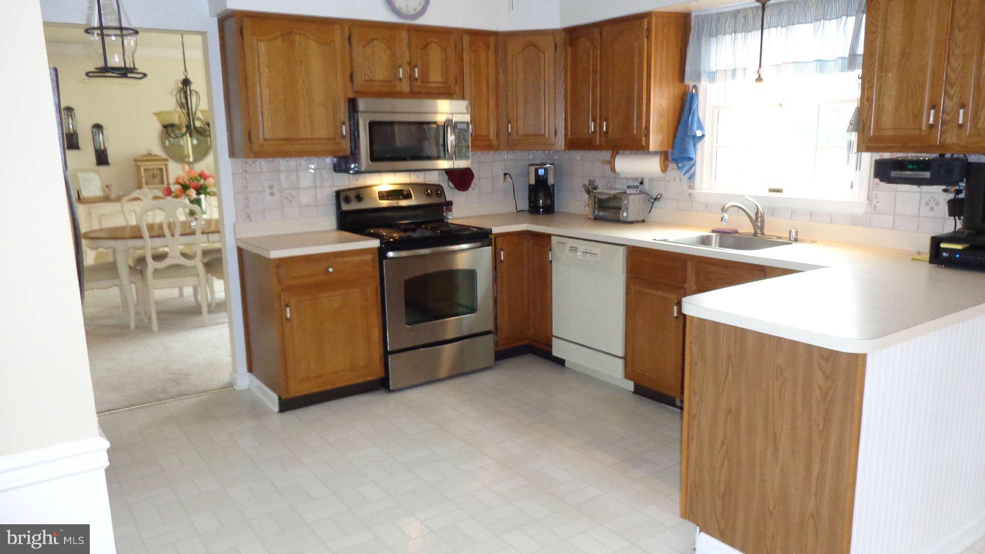Open kitchen has oak cabinetry