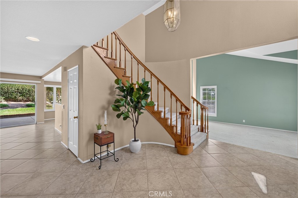 The formal entry offers plenty of space to welcome guests before flowing into the family room, where neutral tile creates a clean, cohesive look.