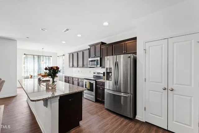 a kitchen with kitchen island a counter top space a sink appliances and cabinets