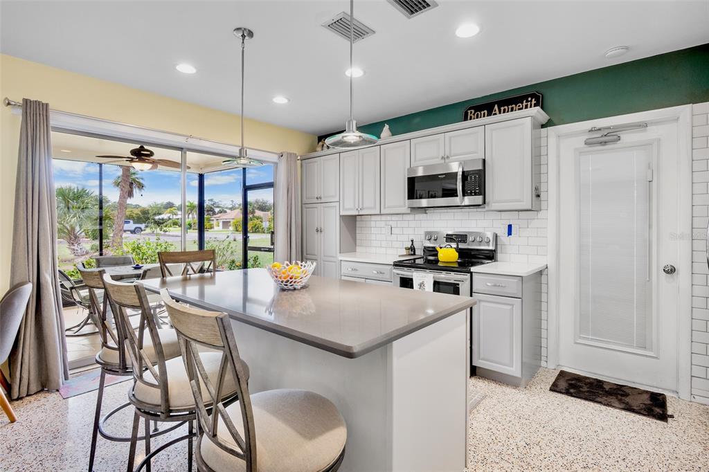 223 Roberts Road Nokomis, FL 34275 - Photo 6 of 27 a kitchen with a sink a counter top space stainless steel appliances and cabinets