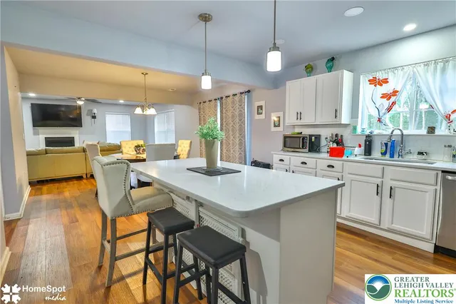 a dining room with furniture a chandelier and wooden floor