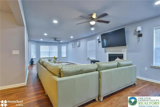 a view of a room with wooden floor chandelier and windows