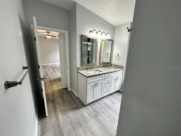 wooden floor in an entryway with a mirror