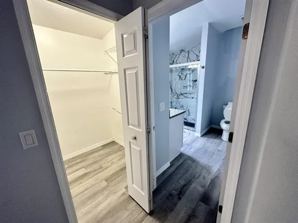 a view of a hallway with wooden floor and staircase