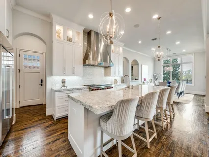 a large kitchen with kitchen island a large island a sink stainless steel appliances and cabinets