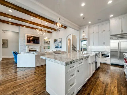 a large kitchen with stainless steel appliances kitchen island granite countertop a lot of counter space and wooden floor