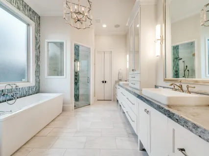 a spacious en suite bathroom with a granite countertop tub sink and mirror