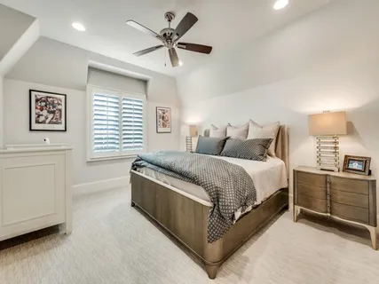 a spacious bedroom with a bed a couch and a window