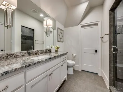 a bathroom with a granite countertop sink toilet and shower