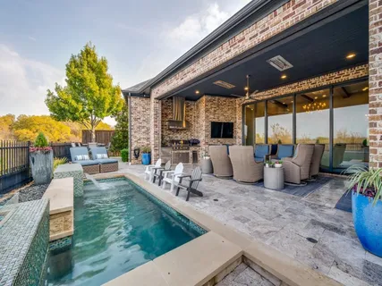 a view of a patio with table and chairs potted plants and large tree