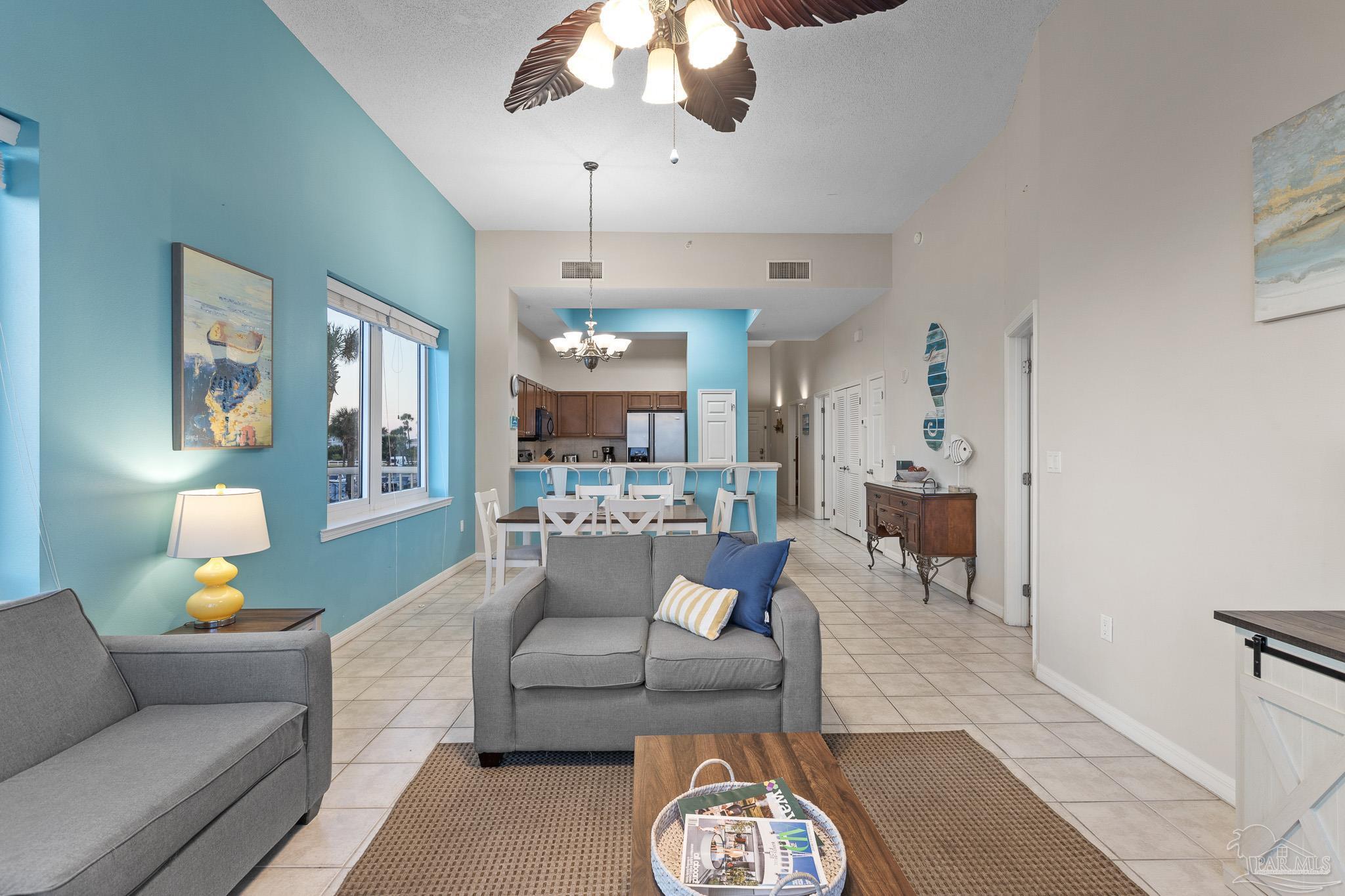 8577 Gulf Boulevard, Unit 105 Navarre Beach, FL 32566 - Photo 12 of 38 a living room with furniture and a chandelier