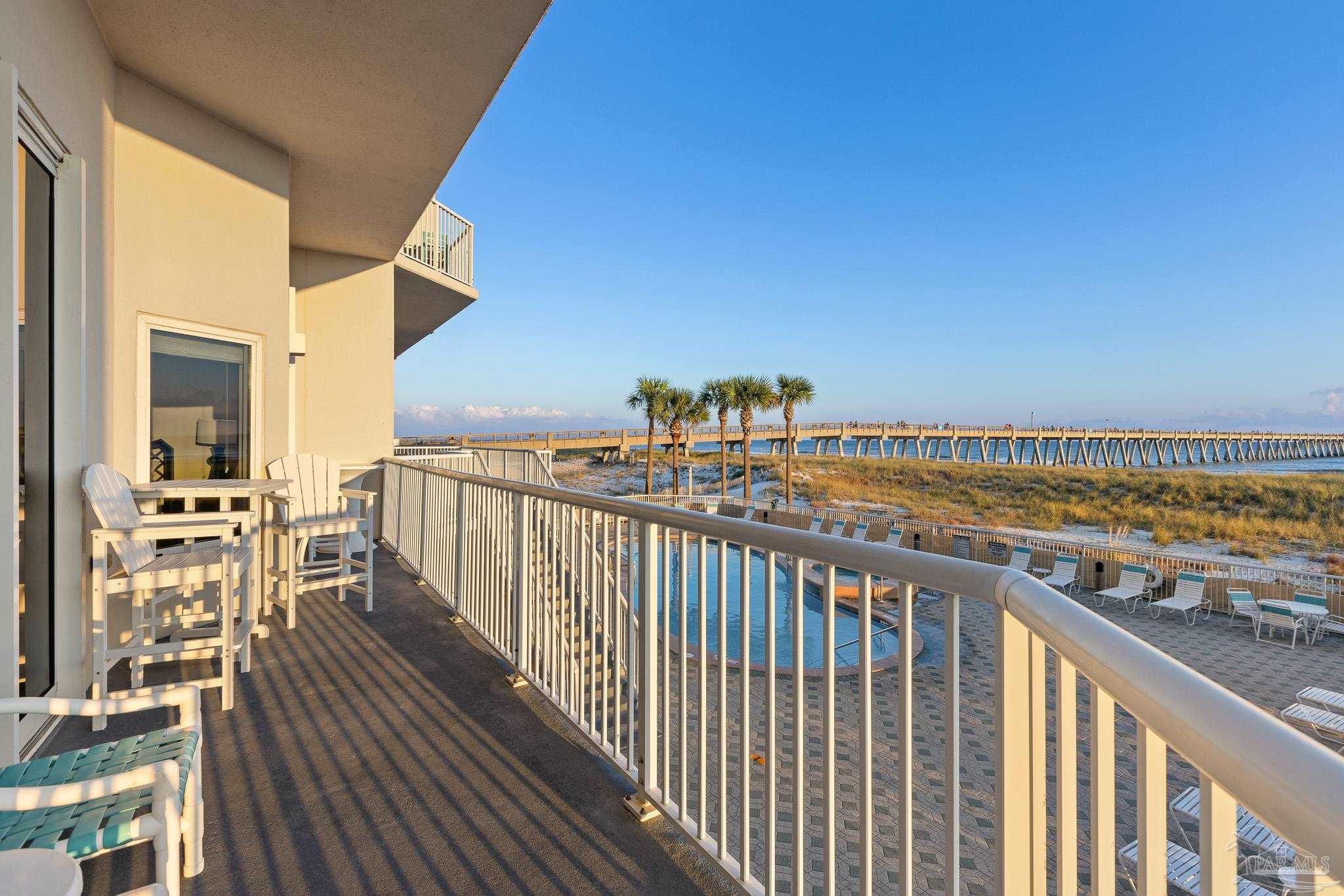 8577 Gulf Boulevard, Unit 105 Navarre Beach, FL 32566 - Photo 26 of 38 a view of a balcony with wooden floor and fence