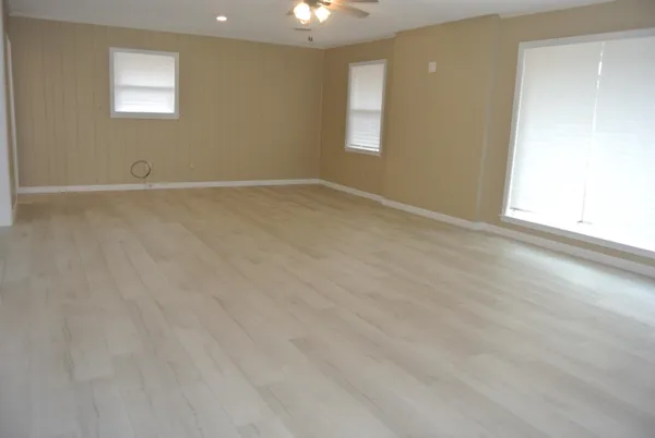 an empty room with closet and a chandelier fan
