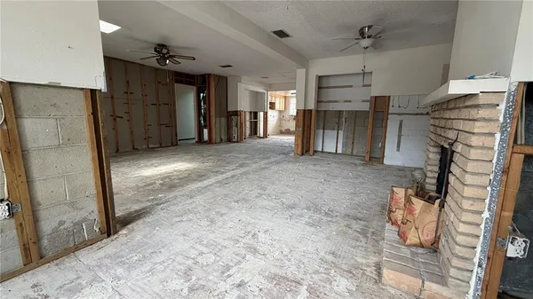 a view of an empty room with a fireplace and a window