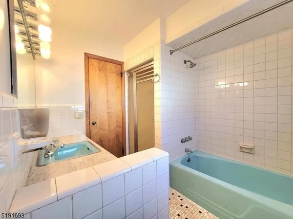 a bathroom with a tub sink and mirror