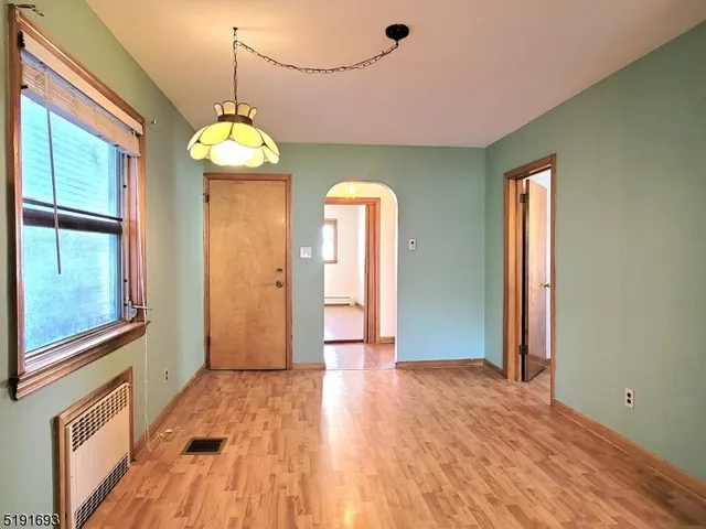 a view of a room with wooden floor chandelier and windows