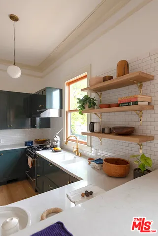 a kitchen with sink a stove and chairs