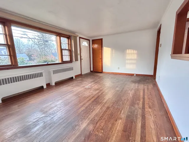 a view of an empty room with wooden floor