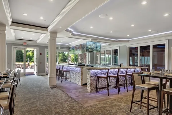 a room with lots of tables a large window and chairs