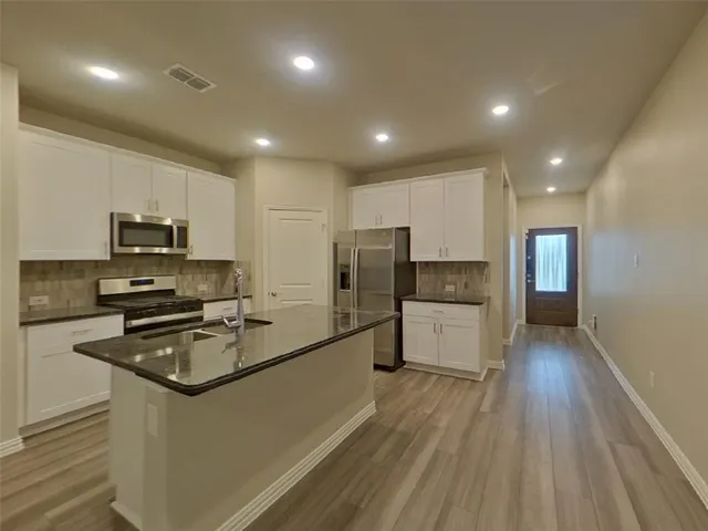 a kitchen with stainless steel appliances a refrigerator sink and microwave