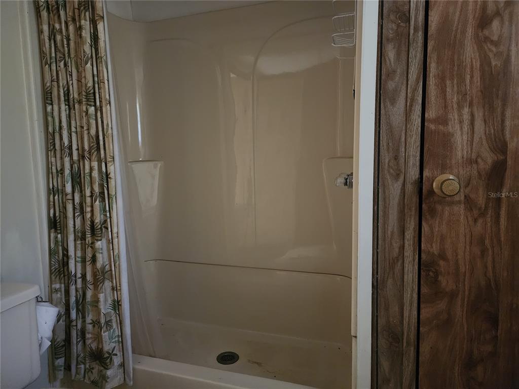 13022 East Shawnee Trail Inverness, FL 34450 - Photo 27 of 80 a bathroom with a glass shower door