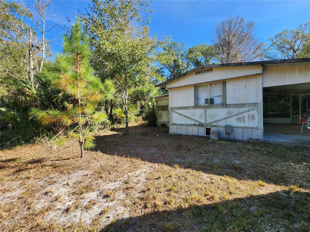 13022 East Shawnee Trail Inverness, FL 34450 - Photo 5 of 80 a view of a house with a yard tree and a wooden fence