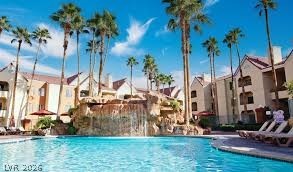 260 East Flamingo Road, Unit 220 Las Vegas, NV 89169 - Photo 24 of 32 Palm-lined oasis with a resort-style pool and rock waterfall feature.