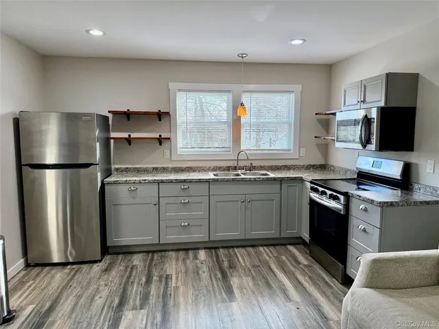 a kitchen with stainless steel appliances granite countertop a refrigerator a stove and a sink