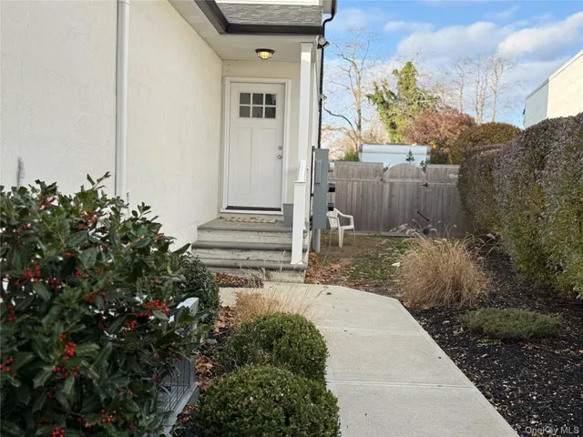 a view of a house with a small yard plants and large tree