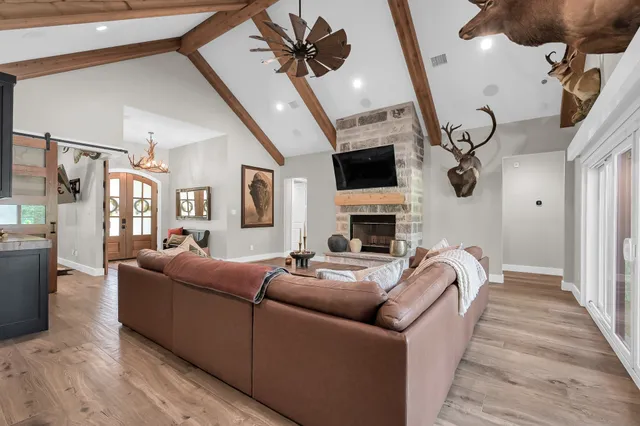 a living room with furniture a fireplace and a chandelier