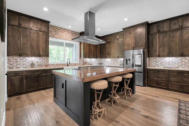 a kitchen with granite countertop a sink appliances cabinets and dining table