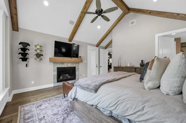 a spacious bedroom with a bed and a flat screen tv