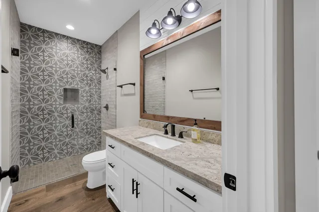 a bathroom with a sink a toilet and shower