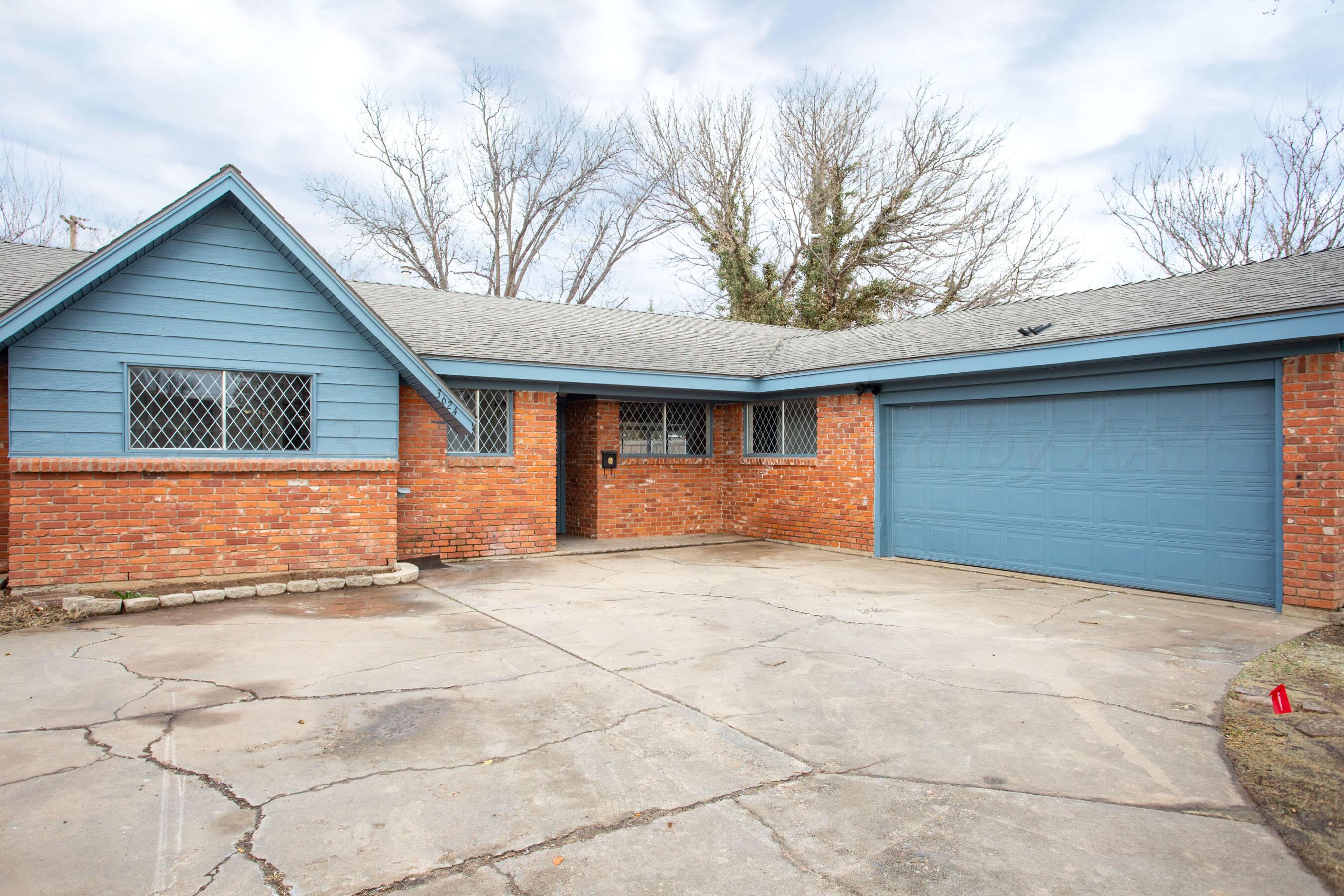 a view of house with yard and trees in the background